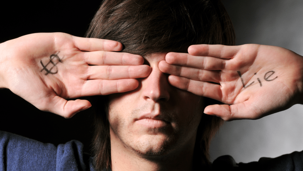 man covering eyes with hand