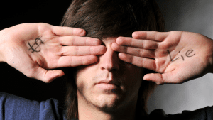 man covering eyes with hand